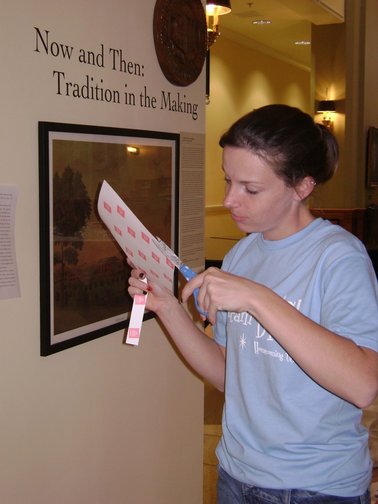Chelsey cuts labels for the walls of the Cochenour Gallery.
