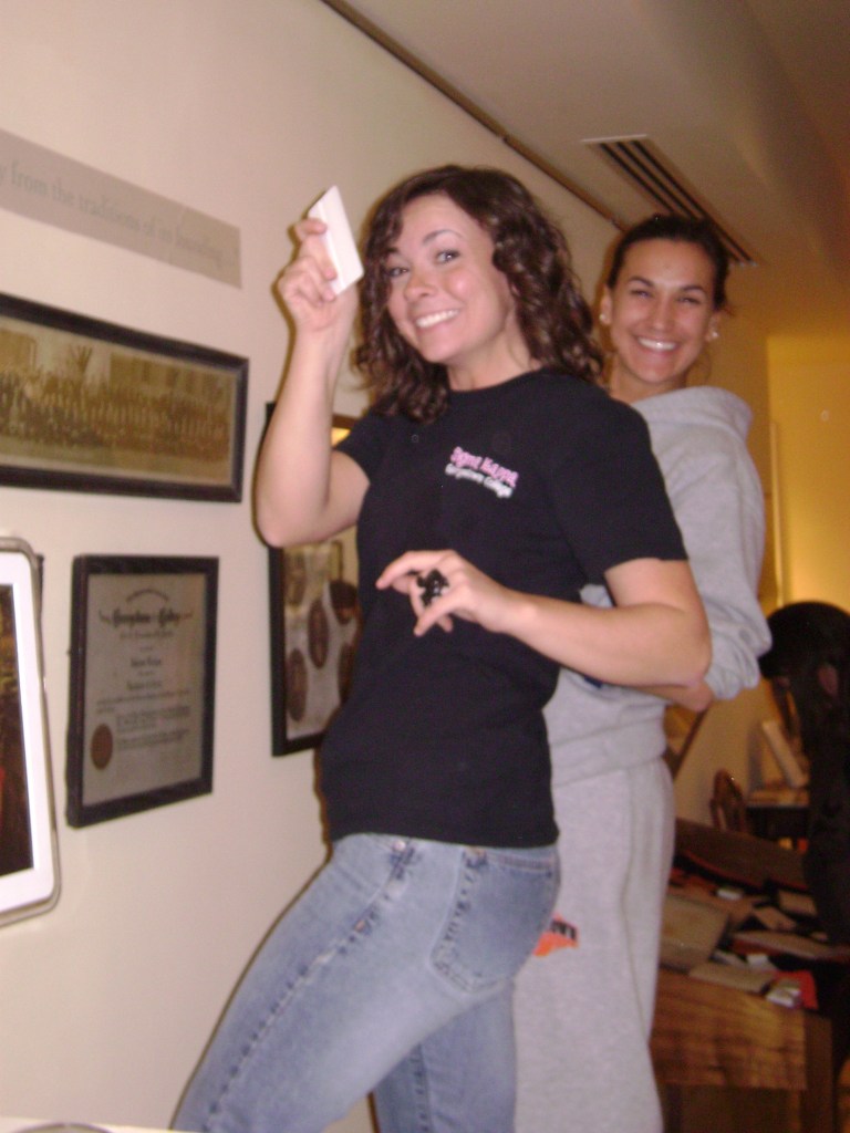 Emily and Makaine mount labels in the Cochenour Gallery.